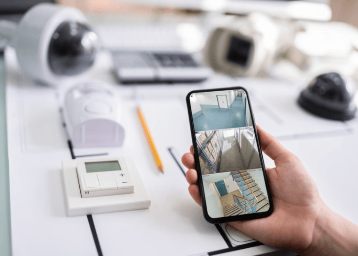 Hand holding smartphone showing room design app with furniture layouts.