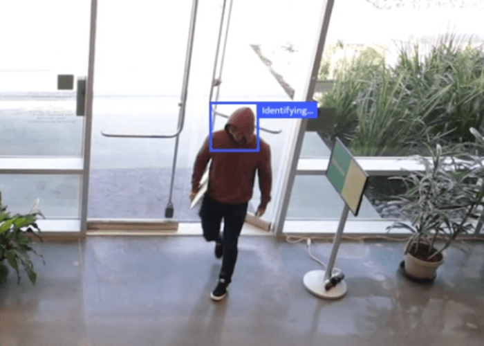 Man in a red shirt walking into a building.